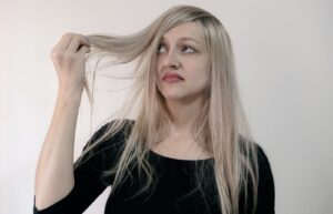 Utah woman looking at her dry brittle damaged hair