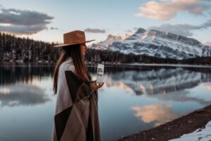 Guide to keeping your skin hydrated | woman in brown coat wearing brown hat standing near lake during daytime