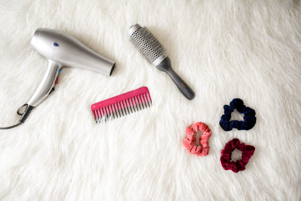 Cosmetology School - Tools and Supplies Every Student Needs - gray corded hair dryer and red comb