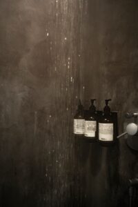 grayscale photo of bottles on wooden table