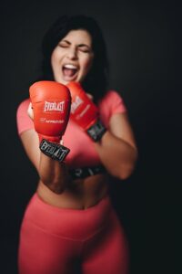 A woman in pink and red boxing gloves