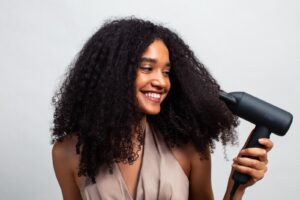 a woman holding a hair dryer and smiling