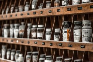 clear glass bottles on brown wooden shelf