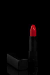 a red lipstick sitting on top of a black surface