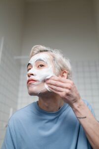 Man in Blue Crew Neck Shirt With Cream On Face