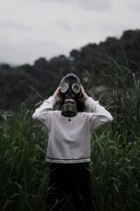 Person in Gas Mask Standing in Hayfield