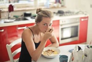 Photo of a woman in a black top eating cereals