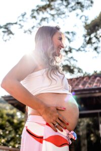 a pregnant woman standing in front of a house