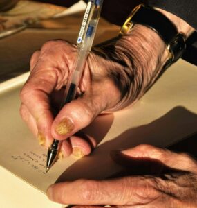 person holding black click pen | Ridges in fingernails