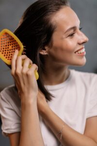 Woman in White Crew Neck Shirt Holding Yellow Plastic Hair Brush | Hair Health