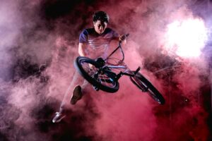 man doing bicycle trick surrounded with red fog