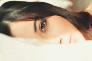 woman covering her face with white textile