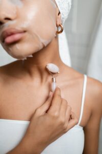 Close-up of a woman using a facial roller during her skincare routine, enhancing beauty and relaxation.