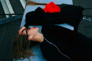 woman in black shirt lying on blue surface