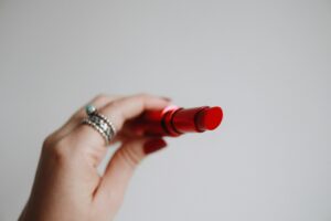 person holding red lipstick | Multi-use makeup