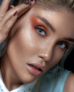 Detailed portrait showcasing vibrant eye makeup and striking blue eyes for a fashion-forward look.