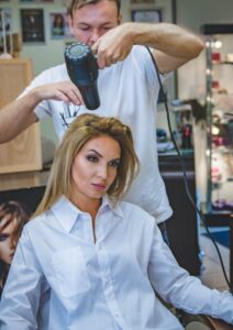 A woman receiving hairstyling services in a salon, showcasing professional grooming.