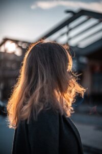 the back of a woman's head as she walks down the street | Frizzy Hair