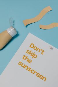 Image of a sunscreen bottle and text emphasizing sun protection on a blue background.