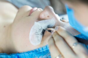 a woman getting her eyelashes done by a professional makeup artist | Lash Retention