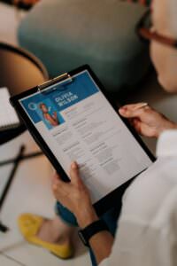 An HR professional reviews a resume on a clipboard during an office meeting. | beauty industry resume