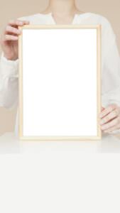 Elegant minimalist wooden frame mockup held by a person on a neutral background, ideal for design presentations.