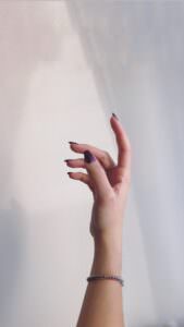 persons left hand on white wall | nail prep techniques
